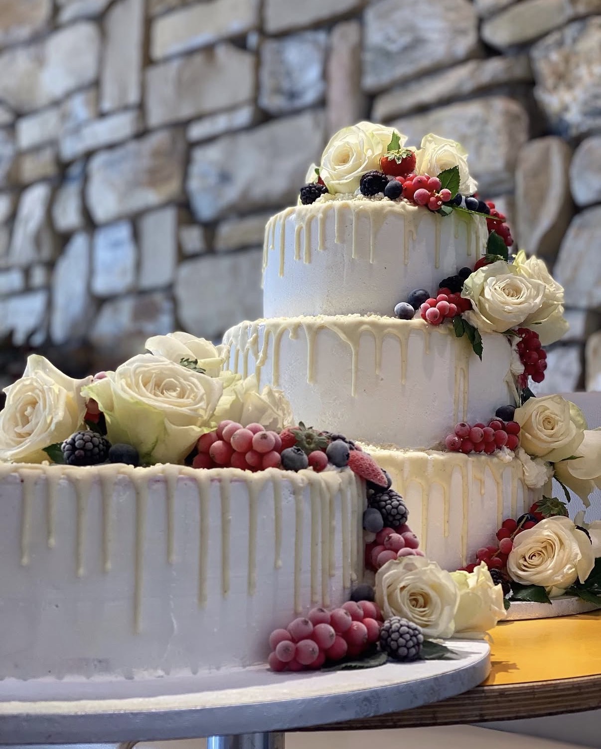 Mehrstöckige Eistorte von mörchens eis mit weißen Rosen und frischen Beeren